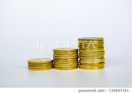 Three stacked coin piles isolated on a white background Three stacked coin piles isolated on a white background 139893761