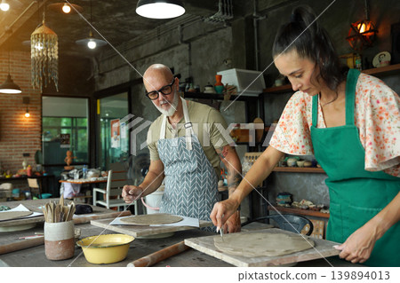 A happy couple makes ceramic plates in a workshop A happy couple makes ceramic plates in a workshop 139894013