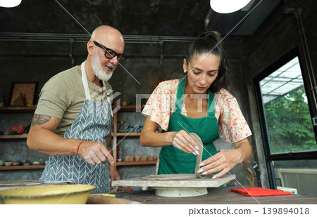 A happy couple makes ceramic plates in a workshop A happy couple makes ceramic plates in a workshop 139894018