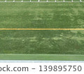 The artificial turf of the soccer field. The vibrant green with yellow lines looks as if it's waiting for the match to begin. 139895750
