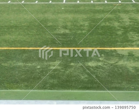 The artificial turf of the soccer field. The vibrant green with yellow lines looks as if it's waiting for the match to begin. The artificial turf of the soccer field. The vibrant green with yellow lines looks as if it's waiting for the match to begin. 139895750