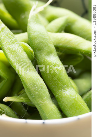一張盛在白色碗裡的新鮮毛豆的照片,展現了夏季蔬菜的風采。 一張盛在白色碗裡的新鮮毛豆的照片,展現了夏季蔬菜的風采。 139896093
