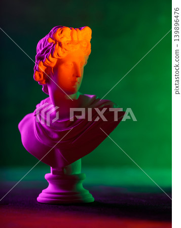 Classical sculpture bust with vibrant orange purple and green gradient neon lighting Classical sculpture bust with vibrant orange purple and green gradient neon lighting 139896476