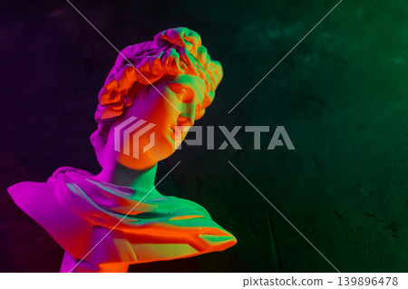 Classical sculpture bust with vibrant neon rainbow gradient lighting on dark background Classical sculpture bust with vibrant neon rainbow gradient lighting on dark background 139896478