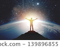 Silhouette of a man with raised hands against the backdrop of the planet and sunset. Elements of this image furnished by NASA 139896855