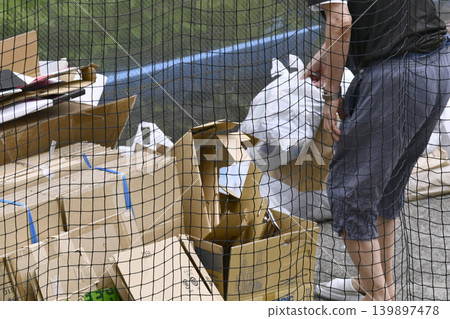 Illegal dumping in Yokohama, Japan... An elderly man throws empty cans and other trash outside of collection days. What's more, he's crossing the border... = Sunday, the 24th 139897478