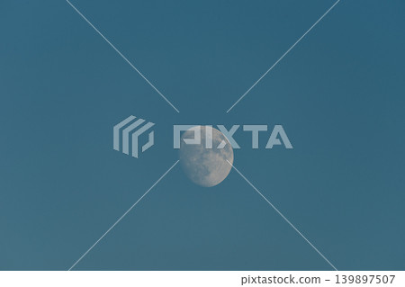 A nearly full moon set against a deep blue sky. A nearly full moon set against a deep blue sky. 139897507