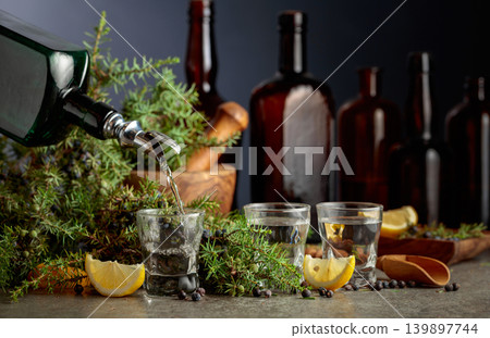 Gin is poured from a vintage bottle into a glass. Gin is poured from a vintage bottle into a glass. 139897744