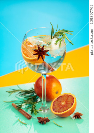 Summer cocktail with gin, tonic, blood orange, cinnamon, anise, and rosemary. Summer cocktail with gin, tonic, blood orange, cinnamon, anise, and rosemary. 139897762