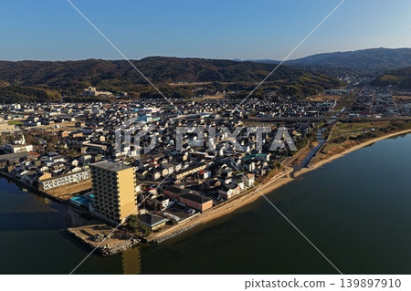 An aerial photograph showing a lakeside residential area along Lake Shinji in Shimane Prefecture, viewed from an oblique angle. 139897910