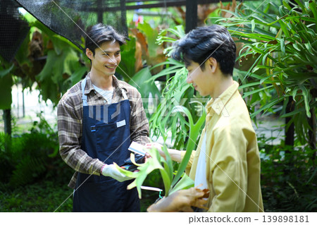 Customer paying by credit card at garden shop, showing modern payment and retail lifestyle Customer paying by credit card at garden shop, showing modern payment and retail lifestyle 139898181