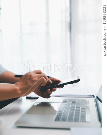Close up hands using stylus on tablet above laptop in bright office desk, showing digital signing, business planning, remote work, technology workflow, and productive workspace concept. 139898222