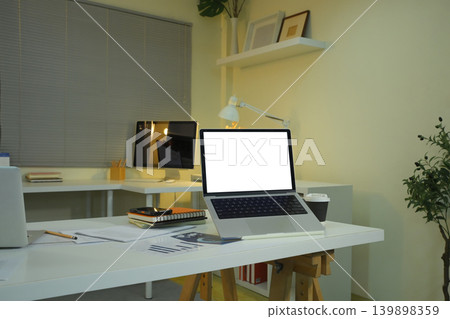 Office workspace with laptop mockup on desk and evening lighting Office workspace with laptop mockup on desk and evening lighting 139898359