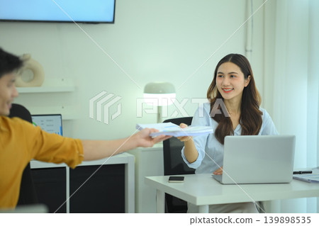 Businesswoman handing financial documents to colleague 139898535