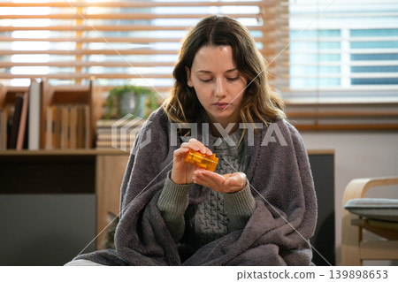 Woman taking medicine at living room 139898653