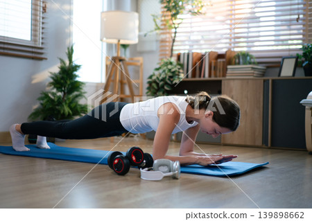 Woman performing forearm plank exercise on yoga mat Woman performing forearm plank exercise on yoga mat 139898662