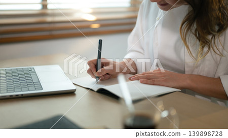 Closeup woman taking notes on table Closeup woman taking notes on table 139898728