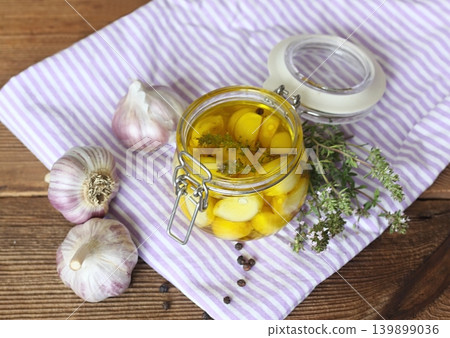 Garlic cloves pickled in olive oil and thyme. 139899036