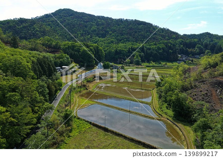 Aerial photograph of a rural landscape with lush green hills and rice paddies. Aerial photograph of a rural landscape with lush green hills and rice paddies. 139899217