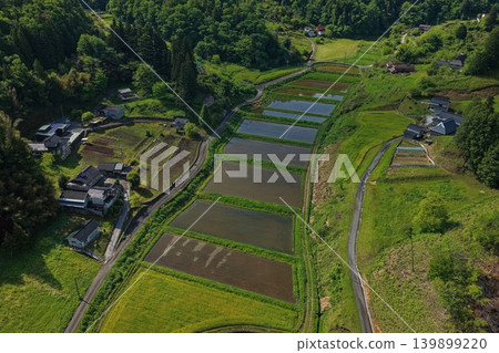 An aerial photograph overlooking rice paddies and rural settlements in the Japanese countryside. An aerial photograph overlooking rice paddies and rural settlements in the Japanese countryside. 139899220