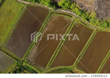 An aerial photograph overlooking a rural landscape with rice paddies stretching out in spring. An aerial photograph overlooking a rural landscape with rice paddies stretching out in spring. 139899222