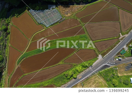 An aerial photograph overlooking farmland and small greenhouses in spring. An aerial photograph overlooking farmland and small greenhouses in spring. 139899245