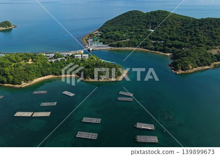 從空中俯瞰瀨戶內市奧町蟲名的牡蠣養殖筏和長島。 從空中俯瞰瀨戶內市奧町蟲名的牡蠣養殖筏和長島。 139899673