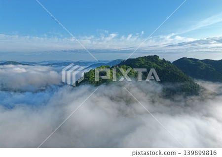 一張空拍照片,捕捉了岡山縣高橋市松山城附近雲海環繞、山頂寺廟和神社的景象。 一張空拍照片,捕捉了岡山縣高橋市松山城附近雲海環繞、山頂寺廟和神社的景象。 139899816