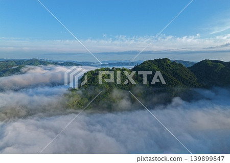 一張空拍照片,捕捉了岡山縣高橋市松山城附近雲海和青山的景象。 一張空拍照片,捕捉了岡山縣高橋市松山城附近雲海和青山的景象。 139899847