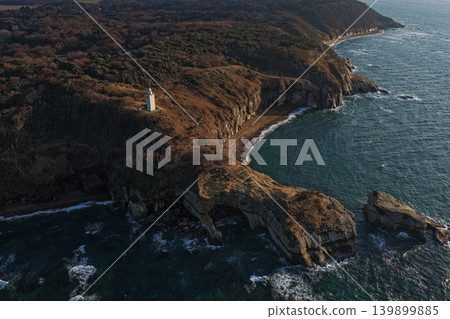 一張空拍照片，展現了石川縣加賀市笠岬的燈塔和懸崖海岸。 139899885