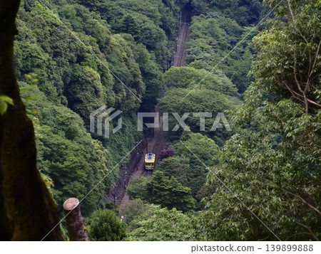 A cable car winds its way through the lush green forests of Takao. A cable car winds its way through the lush green forests of Takao. 139899888