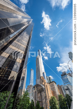 New york, usa august 19,2024. Columbus circle featuring urban skyscrapers and the uss maine monument sphere under a clear blue sky, reflecting modern architecture New york, usa august 19,2024. Columbus circle featuring urban skyscrapers and the uss maine monument sphere under a clear blue sky, reflecting modern architecture 139900095
