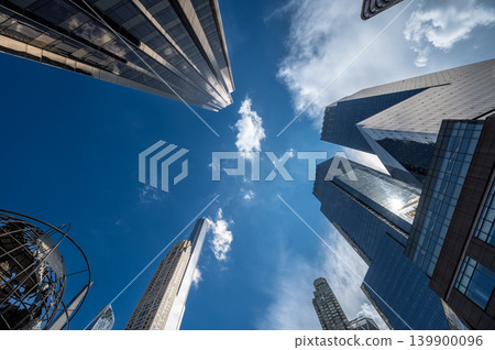 New york, usa august 19,2024. Urban architecture forms an upward perspective of modern glass towers and office buildings against a vibrant blue sky with clouds New york, usa august 19,2024. Urban architecture forms an upward perspective of modern glass towers and office buildings against a vibrant blue sky with clouds 139900096