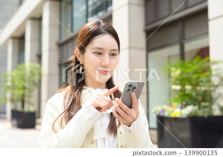 Japanese businesswoman using a smartphone Japanese businesswoman using a smartphone 139900135