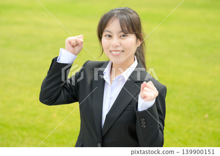 A Japanese woman in her 20s, working in an office, makes a victory pose. A Japanese woman in her 20s, working in an office, makes a victory pose. 139900151