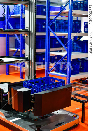 Autonomous robot machine with plastic box in modern industrial warehouse facility. 139900271
