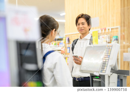 一名男子在收銀台展示他的智慧型手機。 139900738