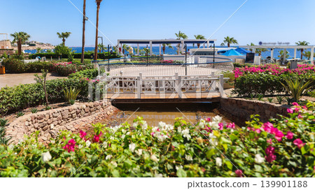A neat pond with a bridge overlooking the sea 139901188