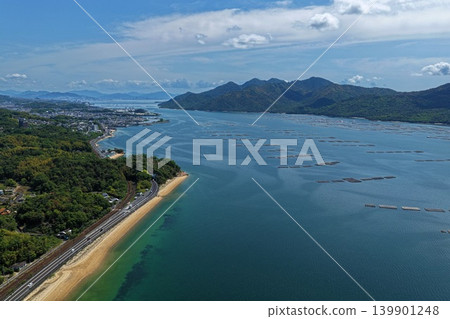 從空中俯瞰廣島縣初日市瀨戶內海沿岸的牡蠣養殖筏和沙灘。 從空中俯瞰廣島縣初日市瀨戶內海沿岸的牡蠣養殖筏和沙灘。 139901248