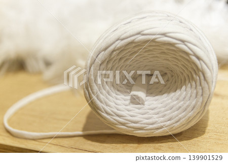 A spool of white cotton rope commonly used for crafts like macrame or as a candle wick A spool of white cotton rope commonly used for crafts like macrame or as a candle wick 139901529