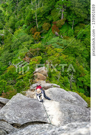 一名女登山者試圖借助鐵鍊攀登大日岳岩壁,這是世界遺產大峰奧掛步道的一段難度較高的路段。 *照片拍攝地點已在評論區註明。 一名女登山者試圖借助鐵鍊攀登大日岳岩壁,這是世界遺產大峰奧掛步道的一段難度較高的路段。 *照片拍攝地點已在評論區註明。 139901689