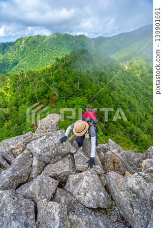 一名女登山者試圖借助鐵鍊攀登大日岳岩壁,這是世界遺產大峰奧掛步道的一段難度較高的路段。 *照片拍攝地點已在評論區註明。 一名女登山者試圖借助鐵鍊攀登大日岳岩壁,這是世界遺產大峰奧掛步道的一段難度較高的路段。 *照片拍攝地點已在評論區註明。 139901691
