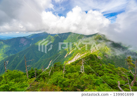 A view of the summer mountain range and fresh greenery from the summit of Mt. Shakagatake on the Omine Okugake Trail, a World Heritage Site. *The shooting location is indicated in the comments section of the work. A view of the summer mountain range and fresh greenery from the summit of Mt. Shakagatake on the Omine Okugake Trail, a World Heritage Site. *The shooting location is indicated in the comments section of the work. 139901699