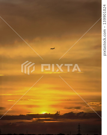 Airplane Silhouette Against Dramatic Golden Sunset Sky Airplane Silhouette Against Dramatic Golden Sunset Sky 139901824