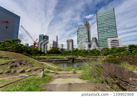 A traditional stone bridge in the former Shiba Rikyu Gardens and a view of the city skyline, September 2023. A traditional stone bridge in the former Shiba Rikyu Gardens and a view of the city skyline, September 2023. 139902908