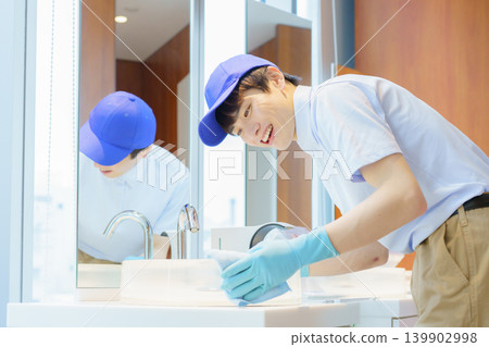 A young Japanese male cleaner cleans a sink in an office building. Photo courtesy of Denpa Gakuen Tokyo Electronics College. A young Japanese male cleaner cleans a sink in an office building. Photo courtesy of Denpa Gakuen Tokyo Electronics College. 139902998