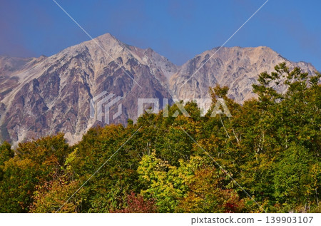 The peaks of Hakuba as seen from Iwatake amidst the autumn foliage. 139903107