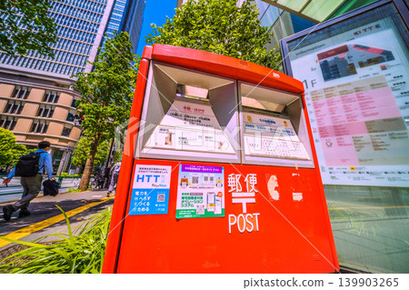 A cityscape of Tokyo, Japan: A mailbox in front of Tokyo Station and KITTE. In the background on the left is the Marunouchi Building in front of JR Tokyo Station. A cityscape of Tokyo, Japan: A mailbox in front of Tokyo Station and KITTE. In the background on the left is the Marunouchi Building in front of JR Tokyo Station. 139903265