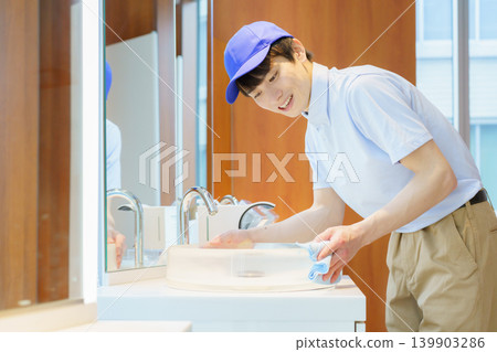 A young Japanese male cleaner cleans a sink in an office building. Photo courtesy of Denpa Gakuen Tokyo Electronics College. A young Japanese male cleaner cleans a sink in an office building. Photo courtesy of Denpa Gakuen Tokyo Electronics College. 139903286