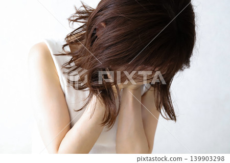 A woman crying with her head down A woman crying with her head down 139903298